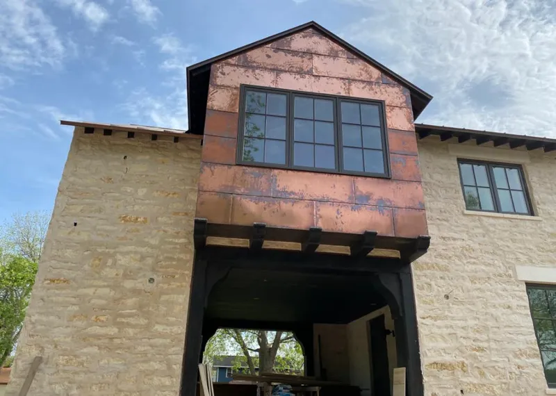 Copper metal panel facade on a stone building for Roof Repair in Cornelius